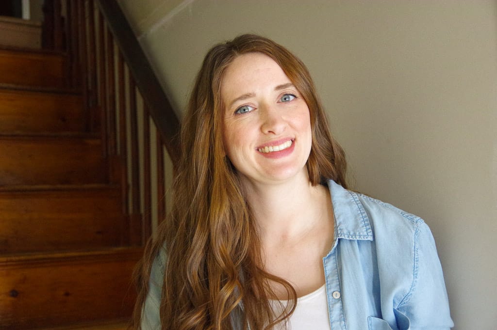 Woman smiling wearing a chambray shirt