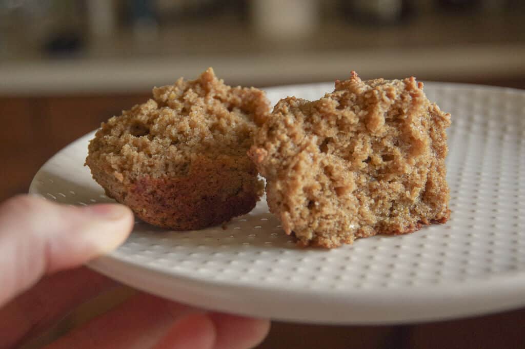 Close up of muffin split in half on a white plate