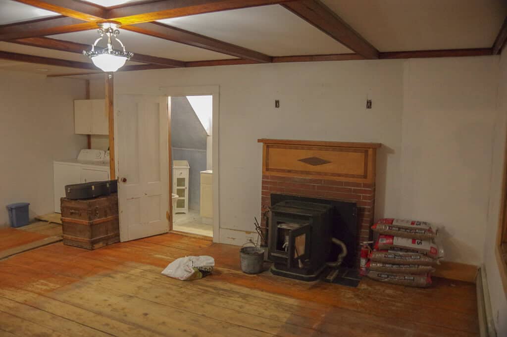 Room with a fire place next to a half bath and washer and dryer.