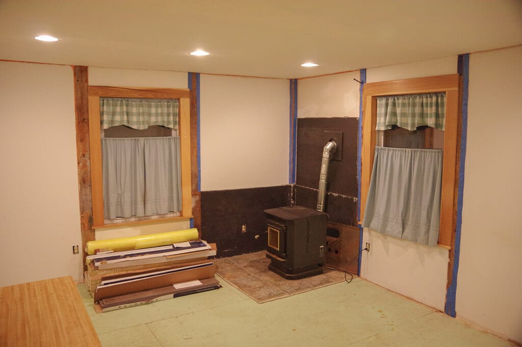 Room with 2 curtained windows and a pellet stove