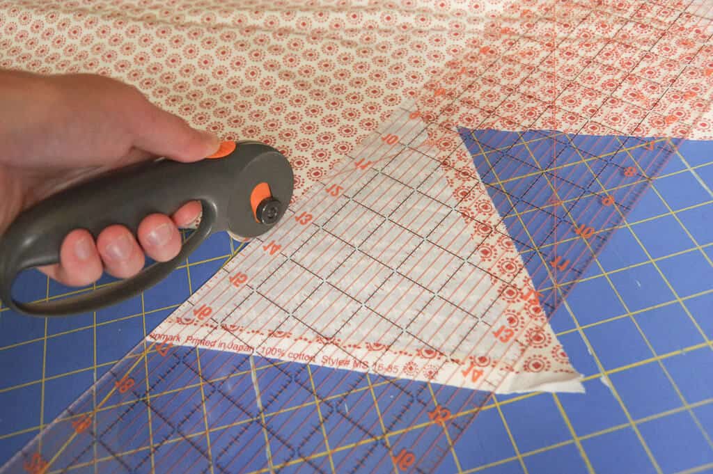 Woman's hand using a rotary cutter to cut fabric