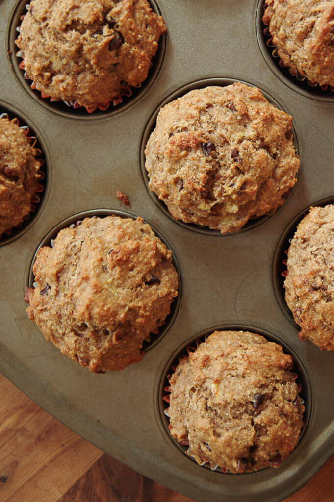 Overhead of muffins in a muffin tin on wooden table