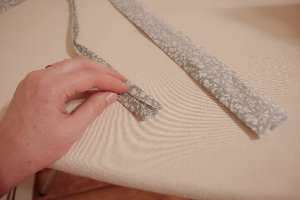 Hand holding ironed strip of fabric