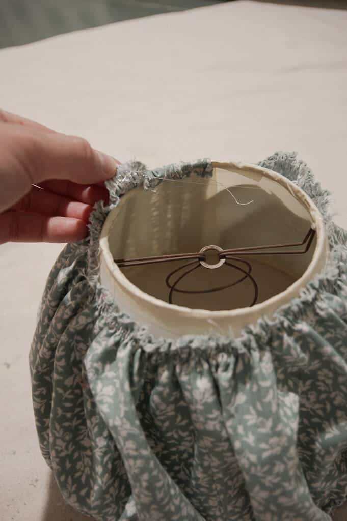 Hand folding fabric over lampshade