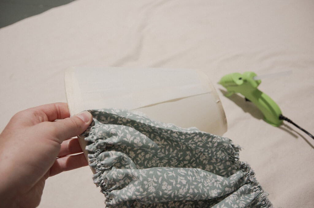 Hand holding fabric on lampshade