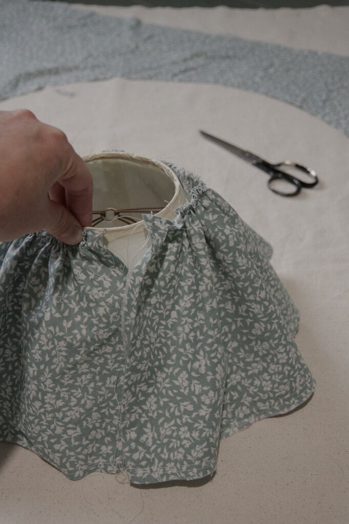 Hand holding fabric on lampshade