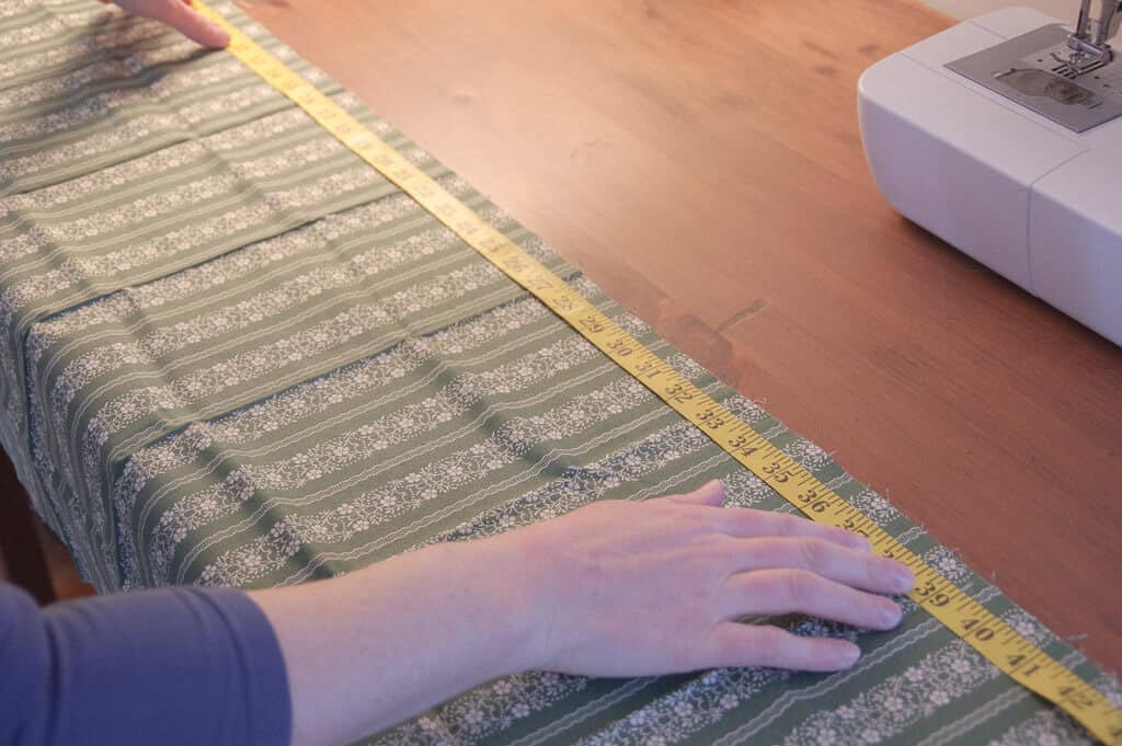 Hands and tape measurer on fabric