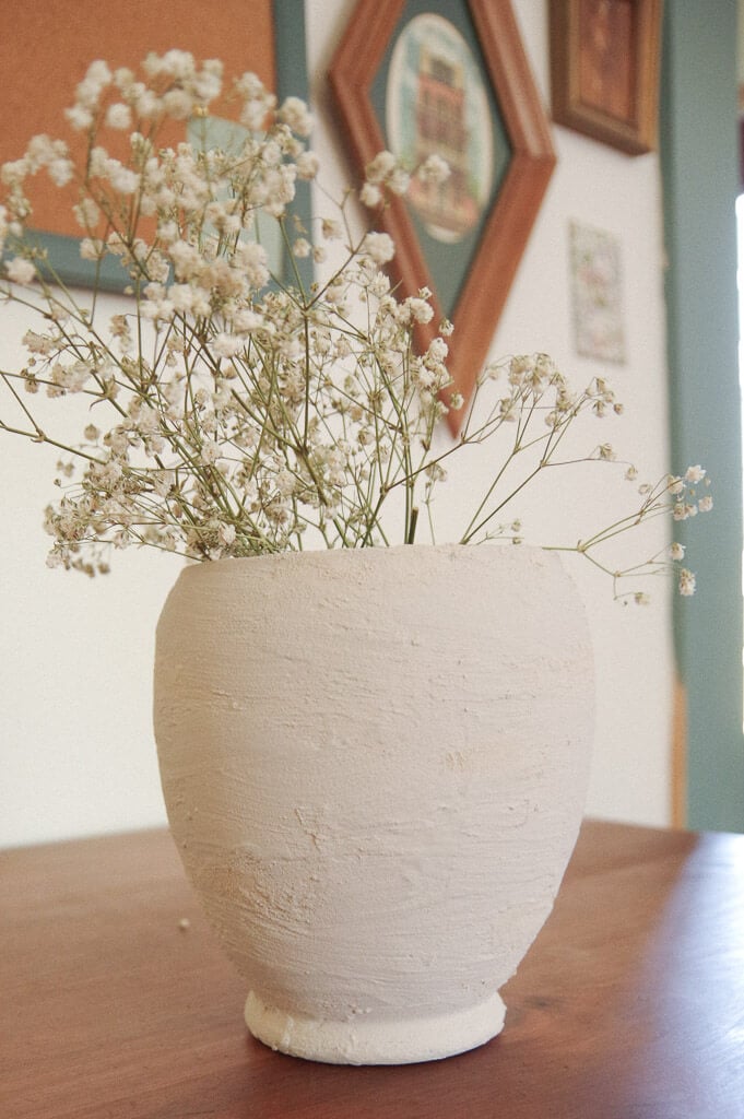 Pottery vase with dried flowers in it on desk