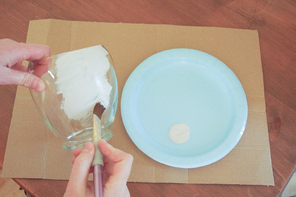 Hands holding a painting a glass vase
