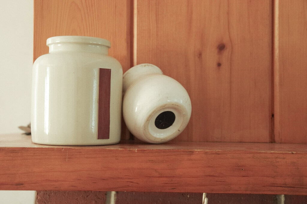 Two ceramic jars on a wooden shelf
